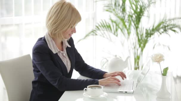 Zakenvrouw zitten aan tafel met behulp van laptop — Stockvideo