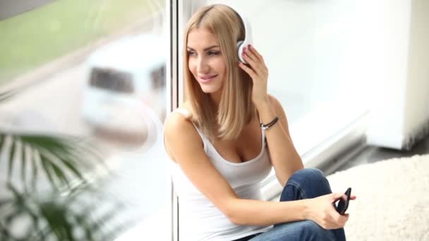 Mujer joven en auriculares sentado — Vídeo de stock