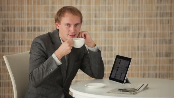 Hombre sentado en la mesa con touchpad — Vídeos de Stock