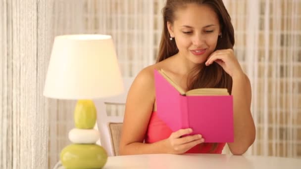 Chica sentada en la cafetería leyendo libro — Vídeos de Stock