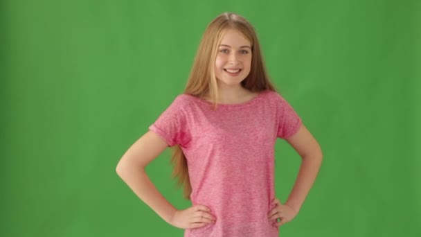 Девушка на зеленом фоне показывает палец вверх — стоковое видео
