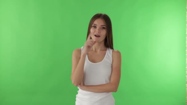 Ragazza su sfondo verde puntando il dito verso l'alto — Video Stock