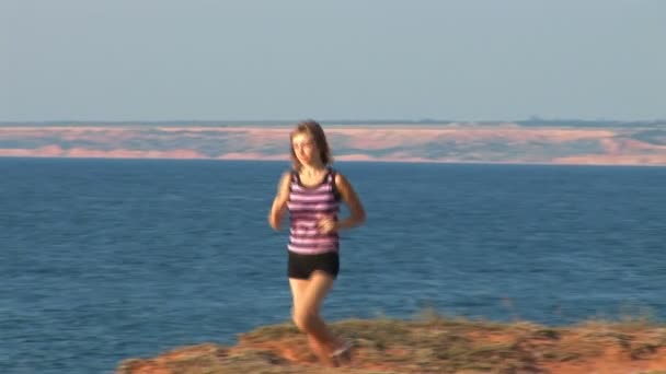 Flicka runing mot havet — Stockvideo