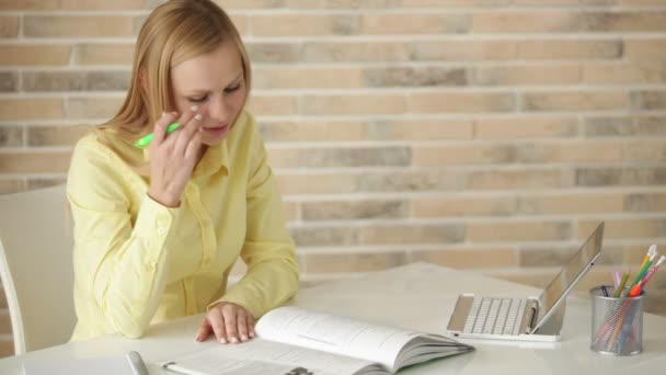 Girl sitting at table writing in notebook — Stock Video