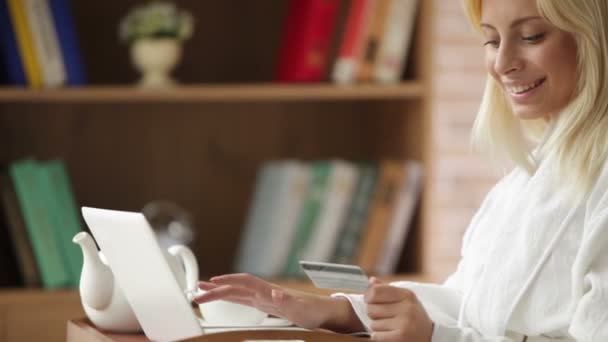 Menina usando laptop segurando cartão de crédito — Vídeo de Stock