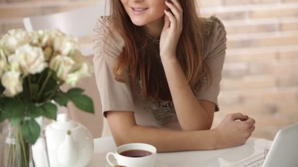 Chica bonita sentada en la cafetería con portátil — Vídeos de Stock