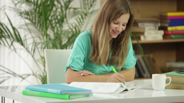 Linda chica sentada en el escritorio estudiando — Vídeo de stock