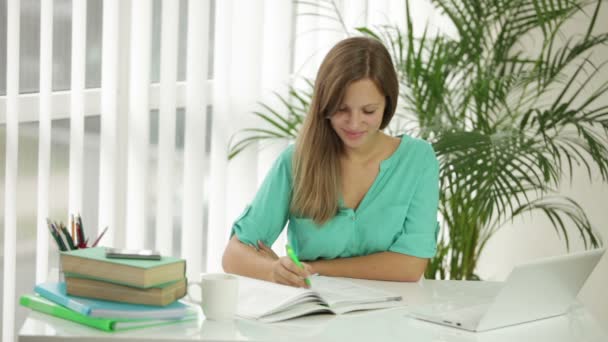 Chica sentada en escritorio escritura en cuaderno — Vídeos de Stock