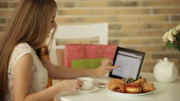 Chica en la cafetería beber té usando touchpad — Vídeos de Stock