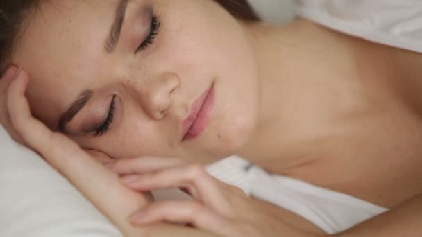 Милая молодая женщина спит в постели — стоковое видео