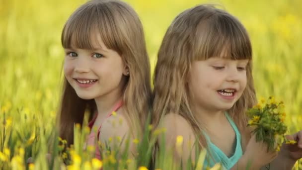 Twee meisjes zitten in bloemen — Stockvideo