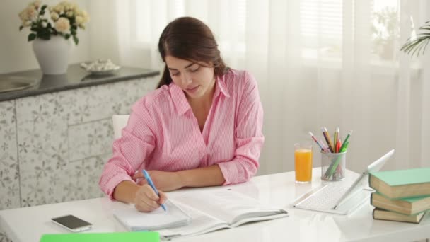 Chica sentada a la mesa escribiendo i — Vídeos de Stock