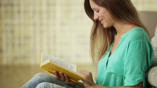 Chica alegre sentado en el libro de lectura de piso — Vídeos de Stock