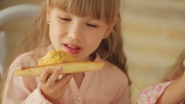 Twee kleine meisjes eten van Pizza — Stockvideo