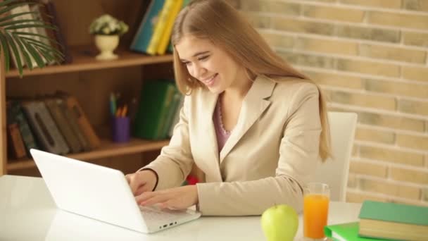 Charmig tjej sitter vid bord med laptop — Stockvideo