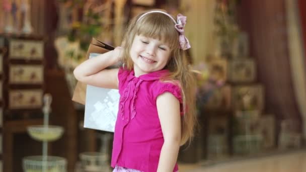 Маленькая девочка с пакетами . — стоковое видео