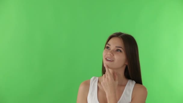 Женщина на зеленом фоне, указывающая пальцем вверх — стоковое видео