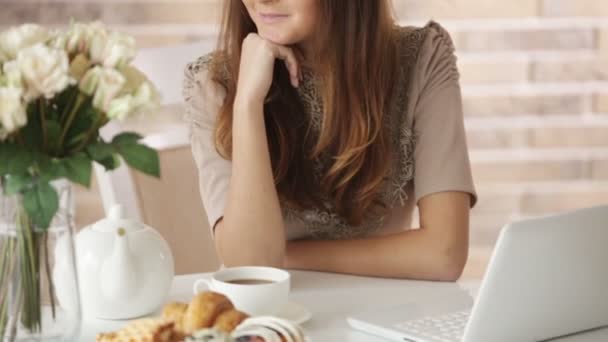 Vrolijk meisje zit in café met laptop — Stockvideo