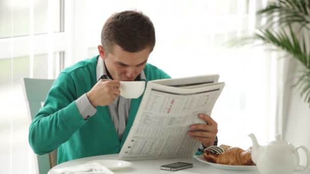 Man reading newspaper and drinking tea — Stock Video