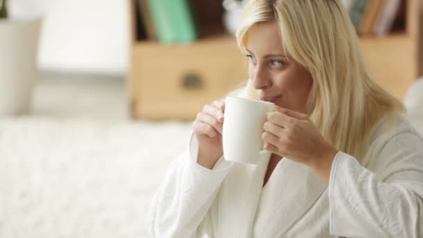 Mujer usando albornoz bebiendo de la taza — Vídeos de Stock