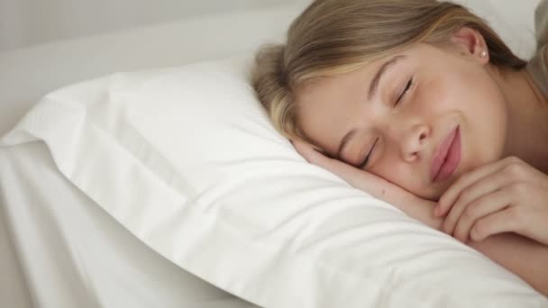 Красивая молодая женщина спит в постели — стоковое видео