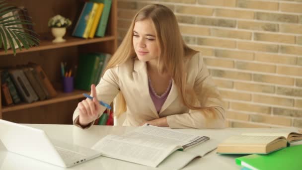 Student meisje zit bij tabel schrijven — Stockvideo