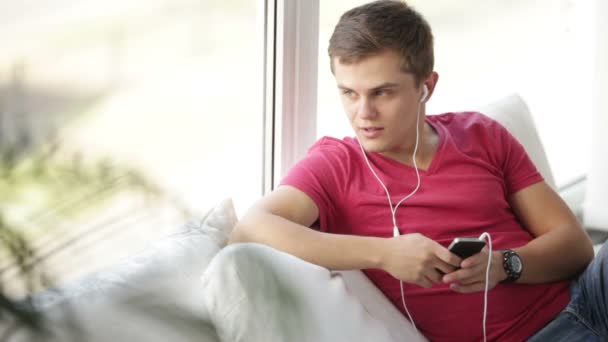 Людина слухає музику на мобільному телефоні — стокове відео