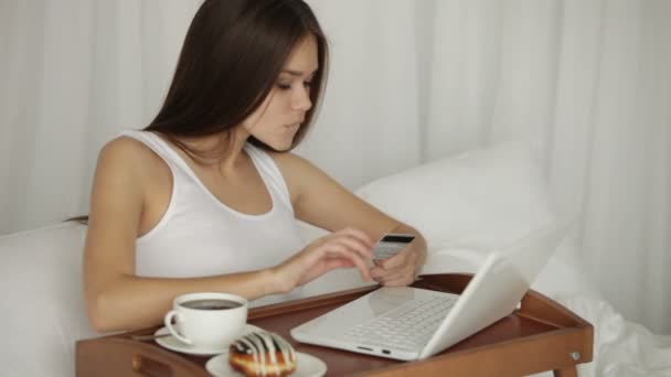 Menina usando laptop segurando cartão de crédito — Vídeo de Stock