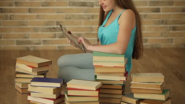 Fille sur le sol avec des livres en utilisant touchpad — Video