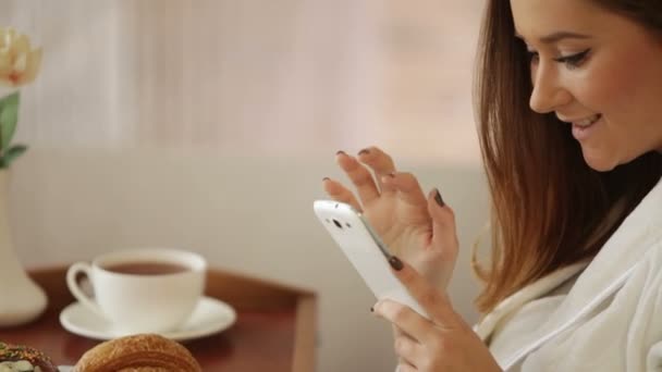 Niña usando albornoz usando teléfono móvil — Vídeos de Stock