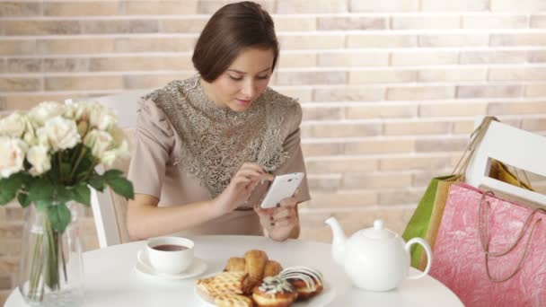 Chica en la cafetería con teléfono móvil — Vídeos de Stock