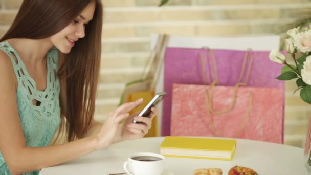 Chica en la cafetería con teléfono móvil — Vídeo de stock