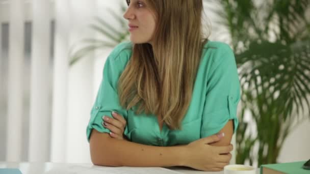 Cheerful student girl sitting at desk smiling — Stock Video