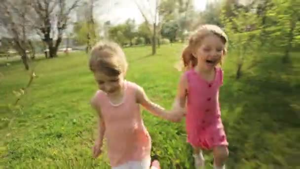 Hermanas corriendo por el jardín — Vídeo de stock