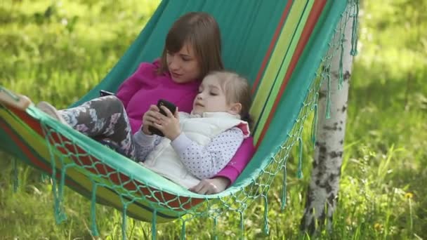 Moeder en dochter liggend in een hangmat — Stockvideo