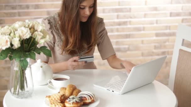 Menina usando laptop segurando cartão de crédito — Vídeo de Stock