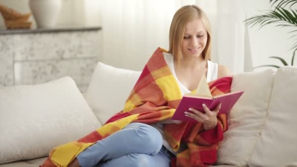 Menina bonito relaxante no sofá leitura livro — Vídeo de Stock