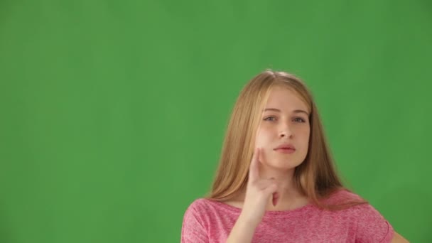 Flicka på grön bakgrund pekar uppåt — Stockvideo