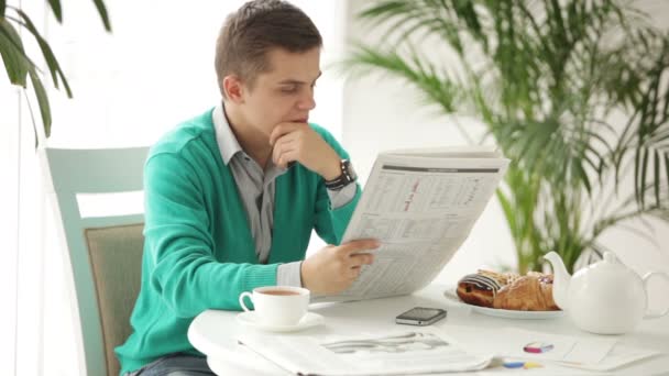 Man sitter vid bordet läsa tidningen — Stockvideo