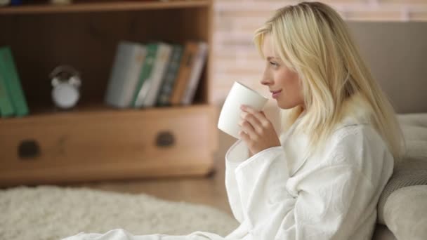 Mujer usando albornoz bebiendo té — Vídeos de Stock