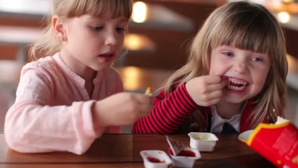 Dos chicas comiendo papas fritas — Vídeo de stock