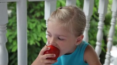 Küçük kız büyük bir kırmızı domates yeme
