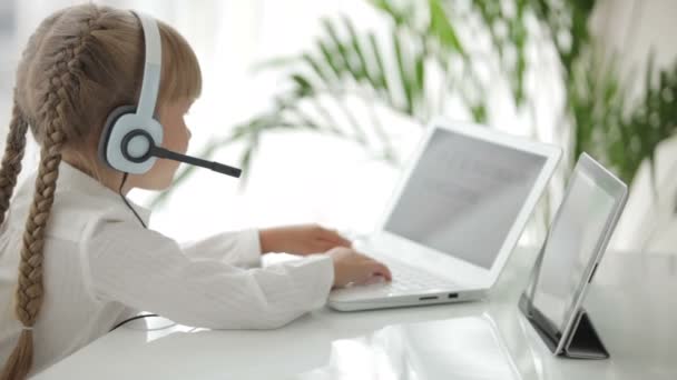 Girl in headset sitting at table — Stock Video