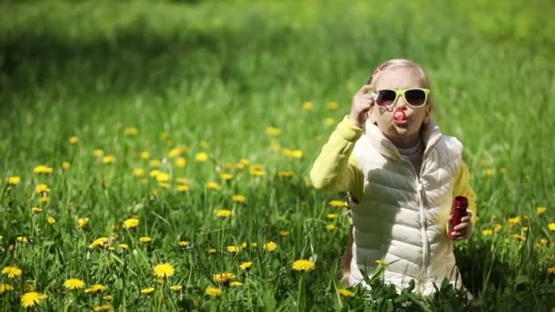 Щаслива дівчина дме мильні бульбашки — стокове відео