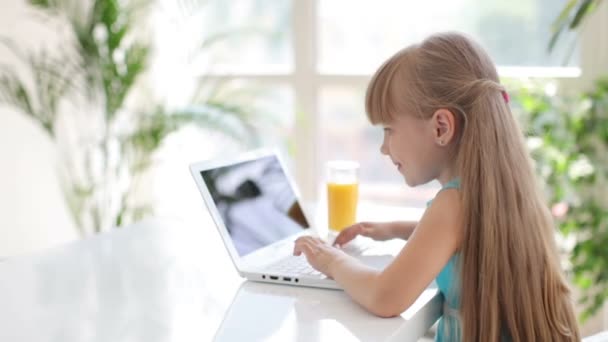 Menina sentada à mesa usando laptop — Vídeo de Stock