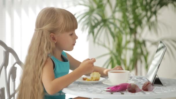 Lustiges kleines Mädchen sitzt am Tisch — Stockvideo