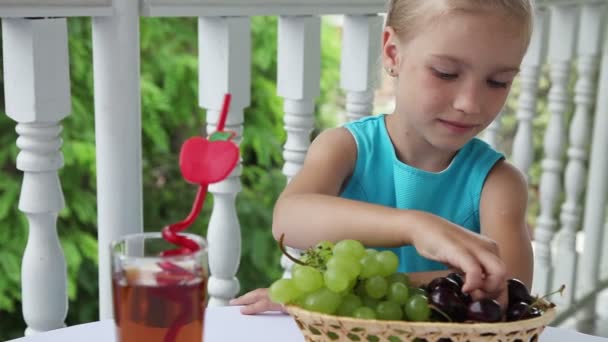 Meisje eten een grote kers. — Stockvideo