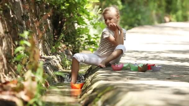 Menina lançando barcos de papel — Vídeo de Stock