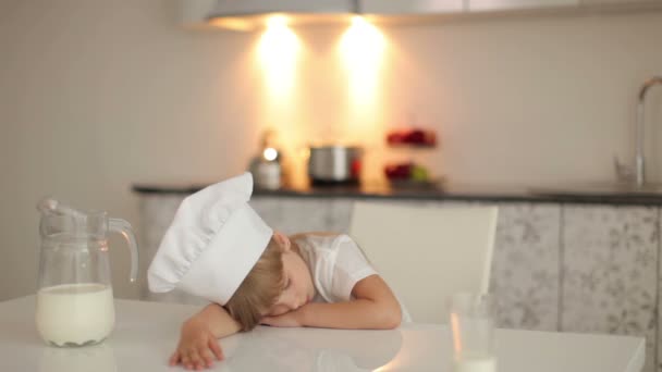 Niña durmiendo en la mesa de la cocina . — Vídeos de Stock