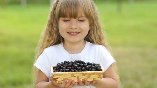 Meisje houden een mandje van zwarte krenten — Stockvideo